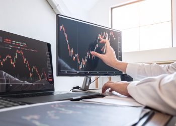 Cropped Hands Of Businesswoman Analyzing Stock Market Data Over Computer In Office